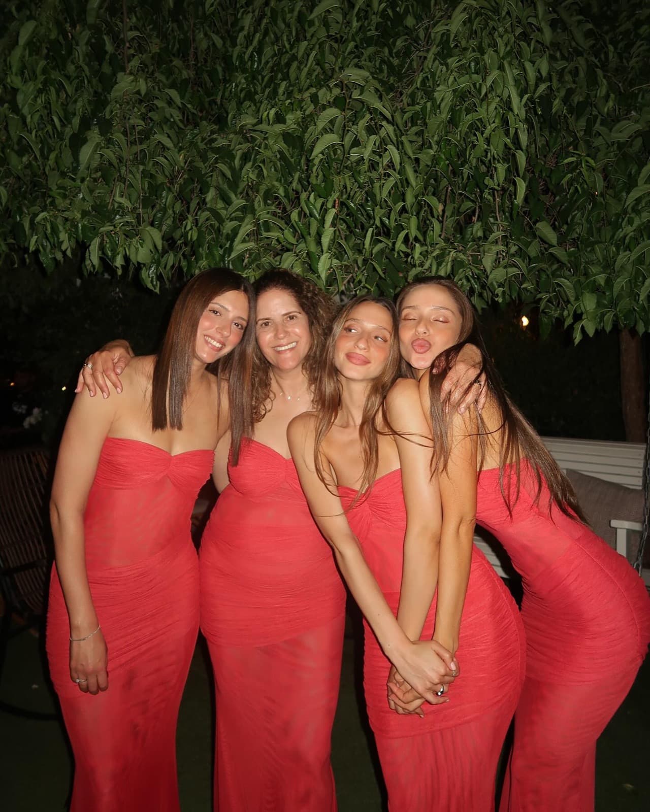 ארבע נשים בשמלות אדומות בערב בגן