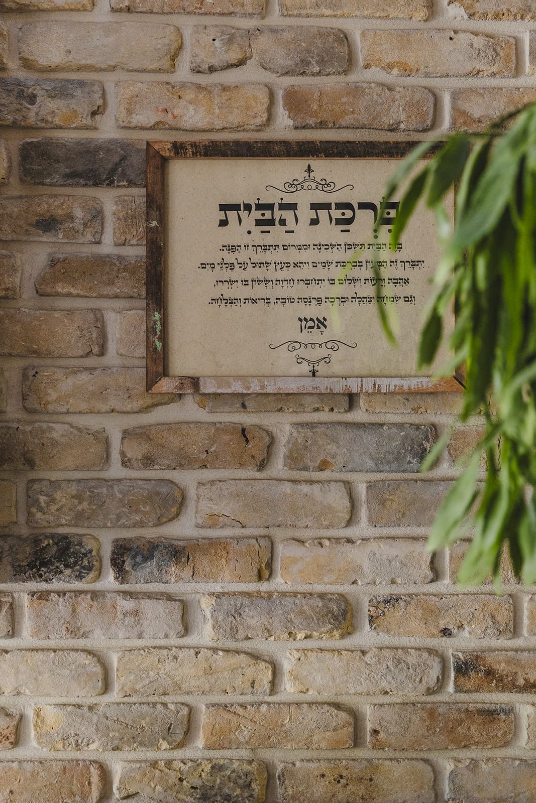 שלט ברכת הבית על קיר לבנים